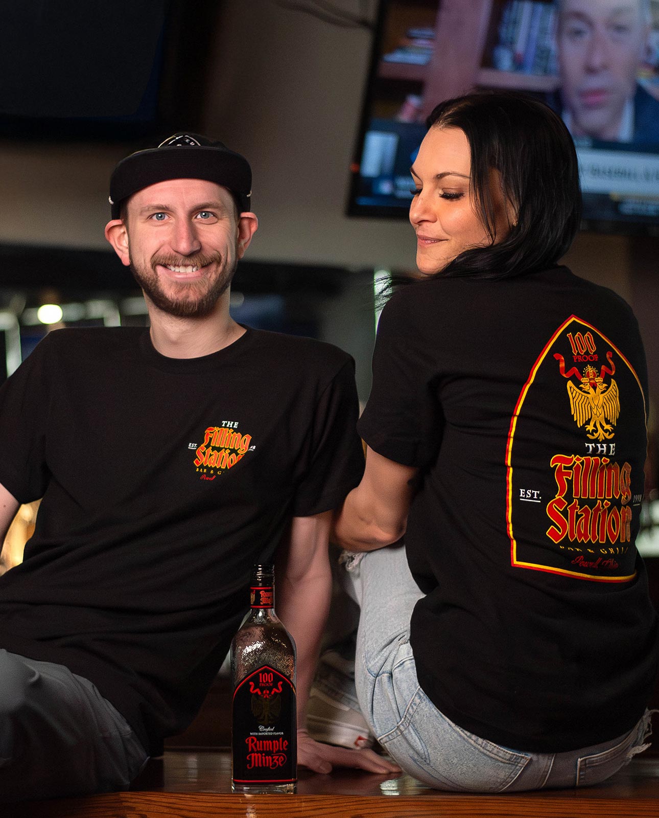 Two people sitting on bar